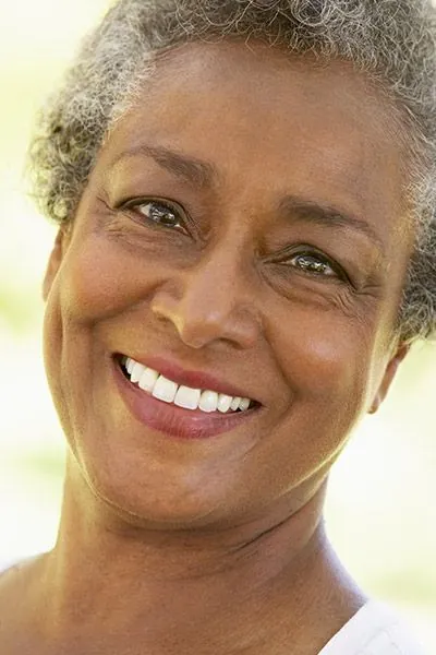 woman with implant-retained dentures smiling