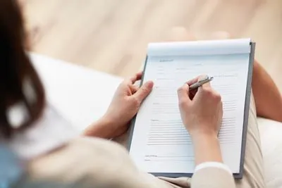 Scott Condie Dentistry patient filling out her dental financing paperwork