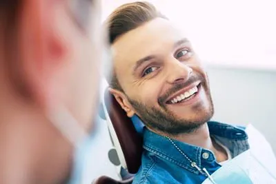 man smiling after getting dental veneers at Scott Condie Dentistry