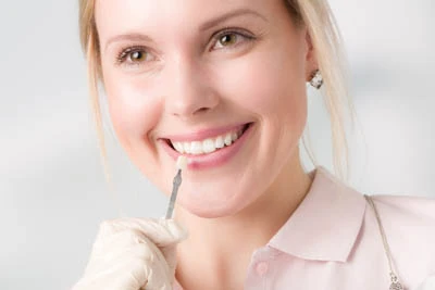 woman choosing the color of dental veneers she would like to get