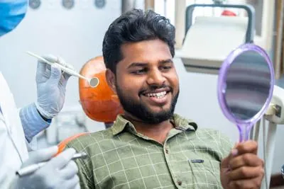 patient looking in the mirror after getting a gum disease treatment procedure