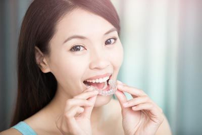 woman putting in her new clear aligners